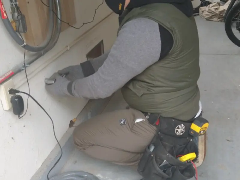 Electrician performing outlet wiring in a Radford garage